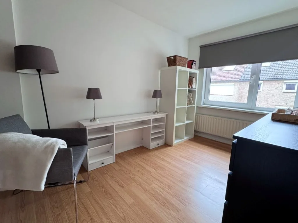 Slaapkamer ingericht met bureau en boekenkast