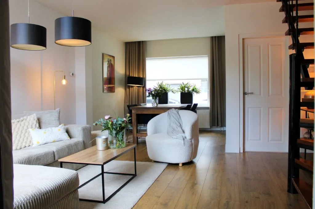 Lichte woonkamer met zithoek en open trap